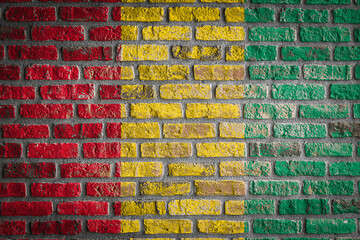 National flag of Guinea. depicting in paint colors on an old brick wall. Flag  banner on brick wall background.