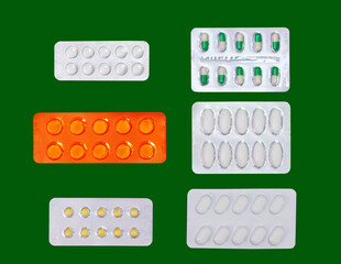 varity of tablets medicine in blisrters on isolated green background