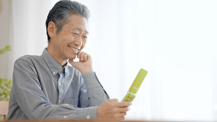 携帯電話を操作するシニア男性