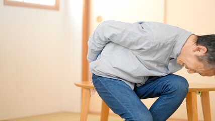 腰をさするシニア男性