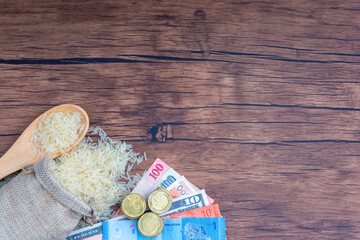 Coins, Banknotes and Rice on wooden background. Zakat concept. Zakat is a form of alm-giving as a religious obligation