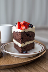 chocolate cake in white plate on wooden table background.