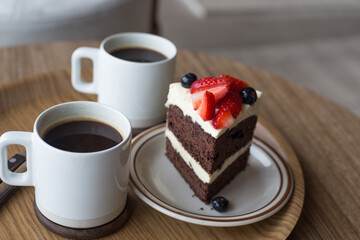 chocolate cake in white plate on wooden table background.