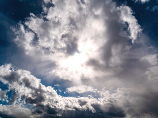 Sun rays shining through the clouds on the blue sky. Sunlight. Blue sky. Cloudy landscape....