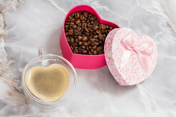 Cup of coffee and roasted coffee beans on kitchen desk.