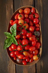 variety of miniature tomatoes on dark wooden surface