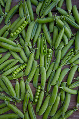 fresh green peas on wooden surface