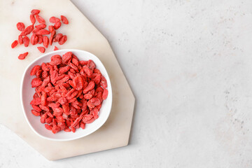 Bowl with dried goji berries on light background © Pixel-Shot