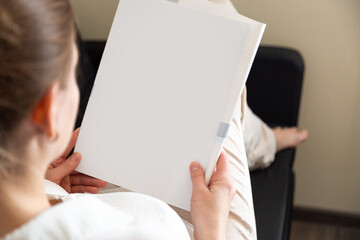 Hand holds white magazine with blank cover mock up. Hand in shirt hold clear magazine mockup template. A4 book softcover surface design.