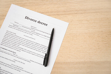 Divorce decree with pen on wooden background