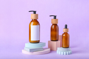 Bottles of cosmetics for hair on color background