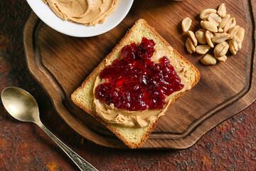 Toast with tasty peanut butter and jam on grunge background