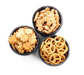 Bowls with tasty different crackers on white background