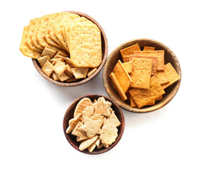 Bowls with tasty different crackers on white background