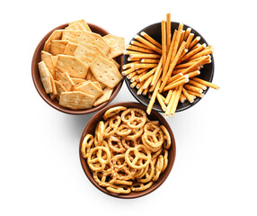 Bowls with tasty different crackers on white background