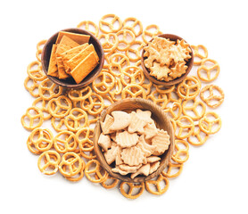 Bowls with tasty different crackers on white background