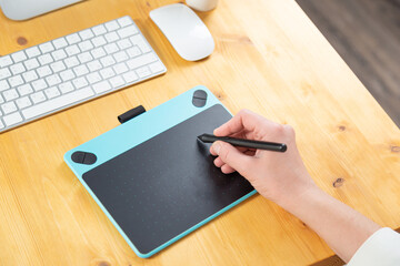 Hand of graphic designer working with stilus and tablet