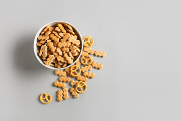 Bowl with tasty different crackers on light background