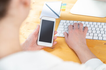 woman hands close up working on white computer keyboard and smartphone, work from home concept. work online, shopping