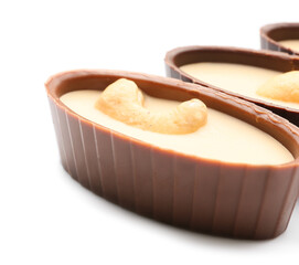 Tasty chocolate candies with nuts on white background, closeup