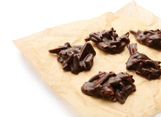 Baking parchment with tasty chocolate candies on white background, closeup