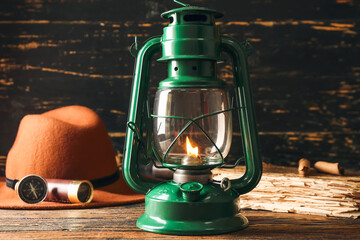 Stylish retro lamp, spyglass and compass on wooden background