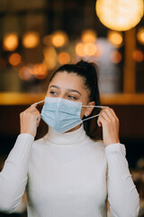 Girl in takes off her protective medical face mask