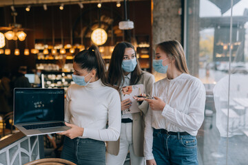 Three businesswomen with their face masks debating different views on work