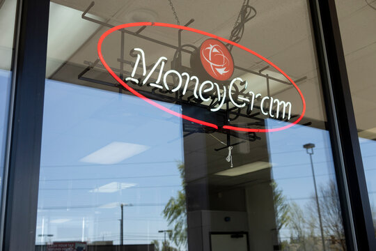 Portland, OR, USA - Apr 16, 2021: MoneyGram sign is seen in the storefront window of an Ace Cash Express office in Tigard, Oregon. MoneyGram International, Inc. is an American money transfer company.