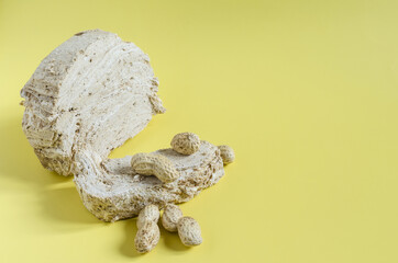 Peanut halva with peanut decor on the bright yellow background of the mine space. Halva of oriental sweets. Halva dessert.