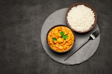 Plate of Traditional Chicken Curry and rice on stone serving board
