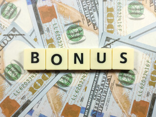 Business concept.Scrabble letters with text BONUS on banknote background.