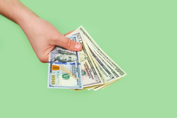 Male hands hold dollar bills, american money on green background. Top view.