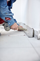 Professional ceramics tile man worker placing new tiles on the floor and wall.
