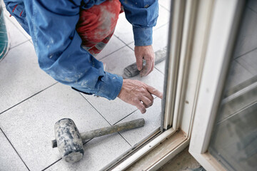 Professional ceramics tile man worker placing new tiles on the floor and wall.