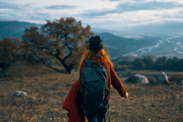 woman hiker with backpack on nature landscape dog