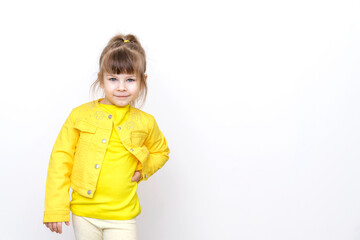 little girl in yellow clothes posing against gray wall background, copy space