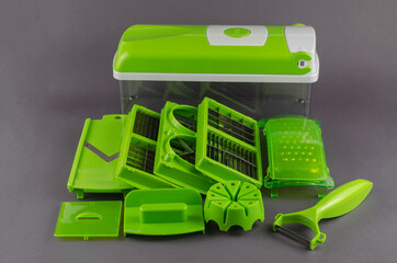 Manual vegetable cutter on a gray background.