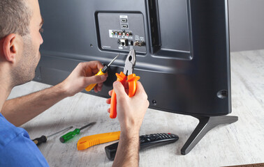 Caucasian engineer repairing Tv at home.