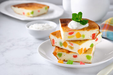 Cottage cheese casserole or pudding served with fresh cream and candied pineapples. Russian breakfast food, zapekanka. Copy space.