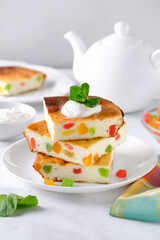 Cottage cheese casserole or pudding served with fresh cream and candied pineapples. Russian breakfast food,  zapekanka.