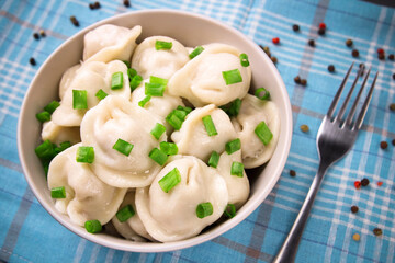 Meat dumplings - Russian dumplings, dumplings with meat on a plate on a black background