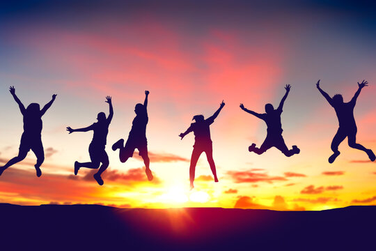 Silhouette happy friends jump on sunset sky at top of mountain abstract background.
