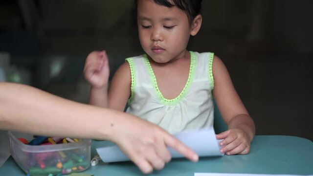 Boring little girl doing homework at table.