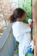 Pretty woman painting her house