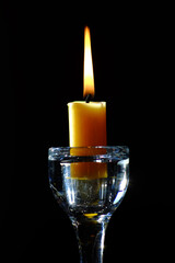 Gelbe Kerze im gläsernen Kerzenständer