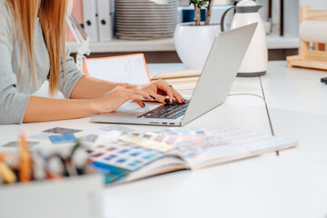 Stand with multicoloured pencils and pens on a table and businesswoman