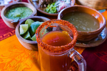 Traditional Mexican michelada in glass mug with blurry background