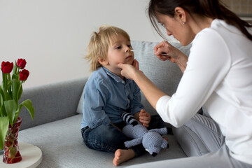 Mother, testing her child for covid at home, making home allowed swab tests