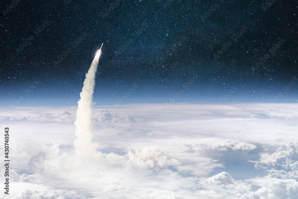 Fototapete Rocket lift off through the clouds and flies into outer deep space. Spaceship successful launch. Planet earth from orbit